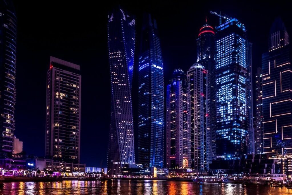 Dubai Marina night skyline with illuminated waterfront towers and reflections – luxury real estate destination presented by Tohid Fetrat