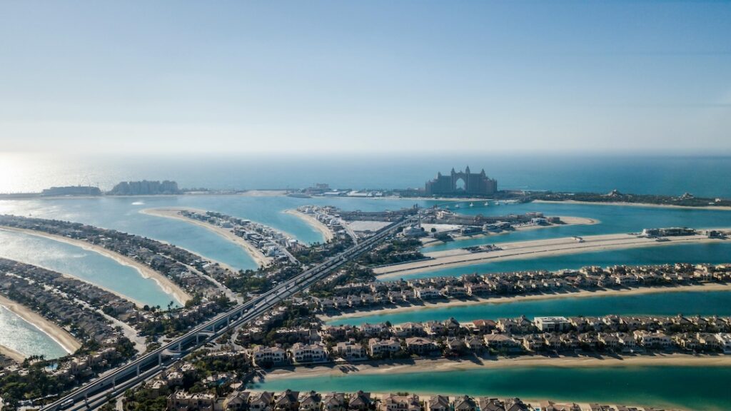 High-resolution aerial view of Palm Jumeirah’s fronds with luxury beachfront properties and the Arabian Gulf.