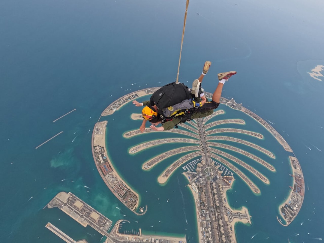Scenic top view of Palm Jumeirah surrounded by blue waters, showcasing the palm design and luxury residences.