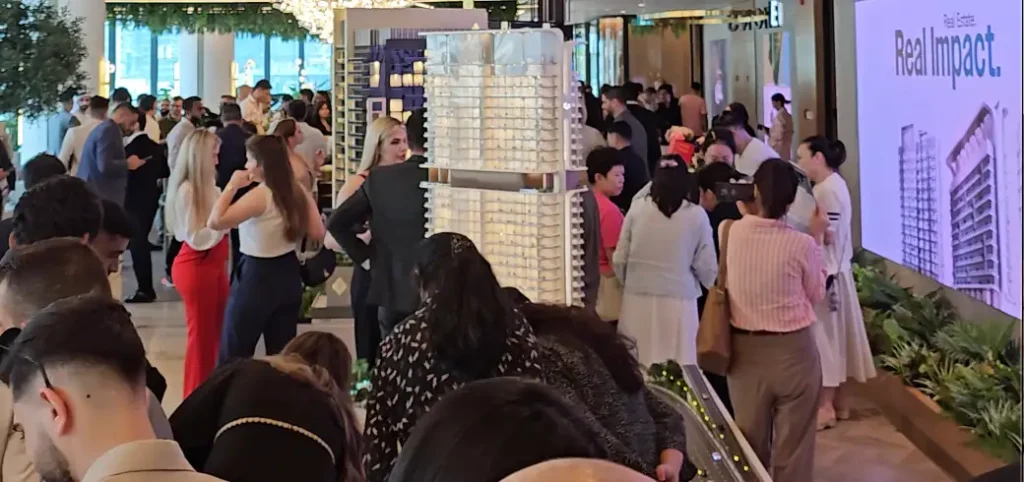 Investors and agents attending an off-plan real estate project launch event in Dubai, showcasing scale models and new property developments.