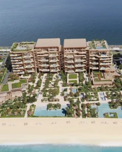 Aerial masterplan view of Alba Residences, Dorchester Collection by OMNIYAT, on Palm Jumeirah, showcasing low rise beachfront architecture, private terraces, landscaped gardens, water features, and direct access to the Gulf shoreline. Presented by Tohid Fetrat.