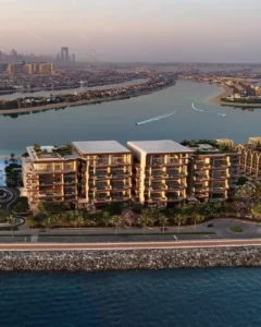 Aerial waterfront view of Alba Residences, Dorchester Collection by OMNIYAT, on Palm Jumeirah, overlooking tranquil lagoon waters, landscaped surroundings, and low rise beachfront architecture with panoramic views of the Gulf. Presented by Tohid Fetrat.