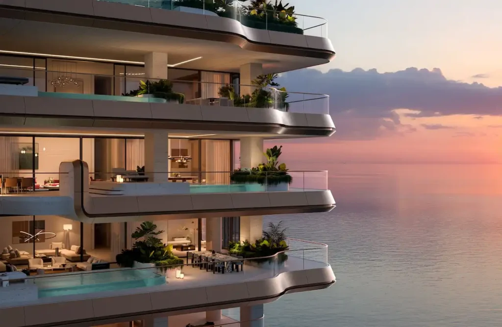 Dusk view of Alba Residences by Dorchester Collection and OMNIYAT on Palm Jumeirah, featuring layered balconies with private infinity pools overlooking the calm Gulf waters. Presented by Tohid Fetrat.
