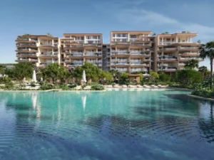 Luxury swimming pool surrounded by landscaped gardens at Alba Residences, Dorchester Collection by OMNIYAT on Palm Jumeirah, featuring contemporary beachfront architecture. Presented by Tohid Fetrat.