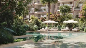 Tranquil garden swimming pool at Alba Residences, Dorchester Collection by OMNIYAT on Palm Jumeirah, surrounded by lush landscaping and luxury beachfront architecture. Presented by Tohid Fetrat.