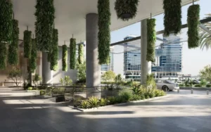 Escalator arrival area of ENARA by OMNIYAT in Marasi Bay, Business Bay, featuring a covered commercial entrance with hanging greenery, landscaped pathways, and contemporary office architecture. Presented by Tohid Fetrat.
