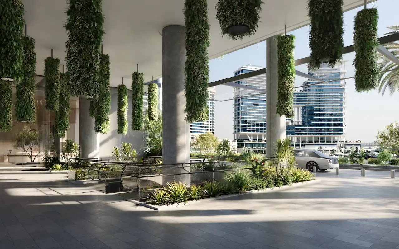 Escalator arrival area of ENARA by OMNIYAT in Marasi Bay, Business Bay, featuring a covered commercial entrance with hanging greenery, landscaped pathways, and contemporary office architecture. Presented by Tohid Fetrat.