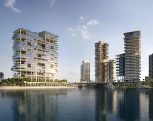 Waterfront view of ENARA by OMNIYAT in Marasi Bay, Business Bay, featuring contemporary commercial towers rising along the marina and reflecting across the calm waterfront. Presented by Tohid Fetrat.
