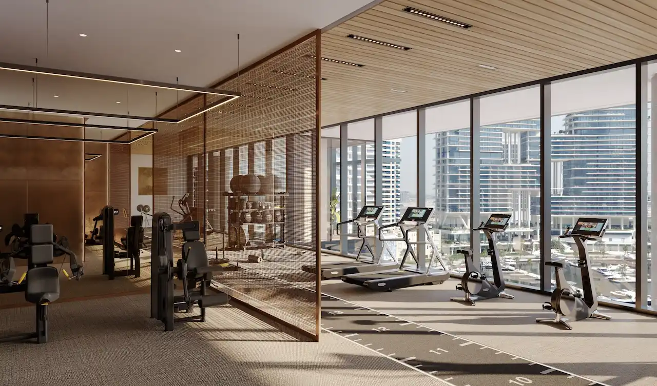 Members club wellness centre gym interior at ENARA by OMNIYAT featuring modern fitness equipment, cardio and strength training zones, floor to ceiling windows, and panoramic Business Bay city views in Dubai. Presented by Tohid Fetrat.