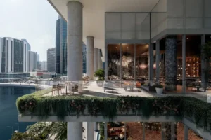 Elevated skydeck terrace at ENARA by OMNIYAT in Business Bay, overlooking the Dubai Canal with outdoor seating, glass façades, and contemporary commercial design. Presented by Tohid Fetrat.