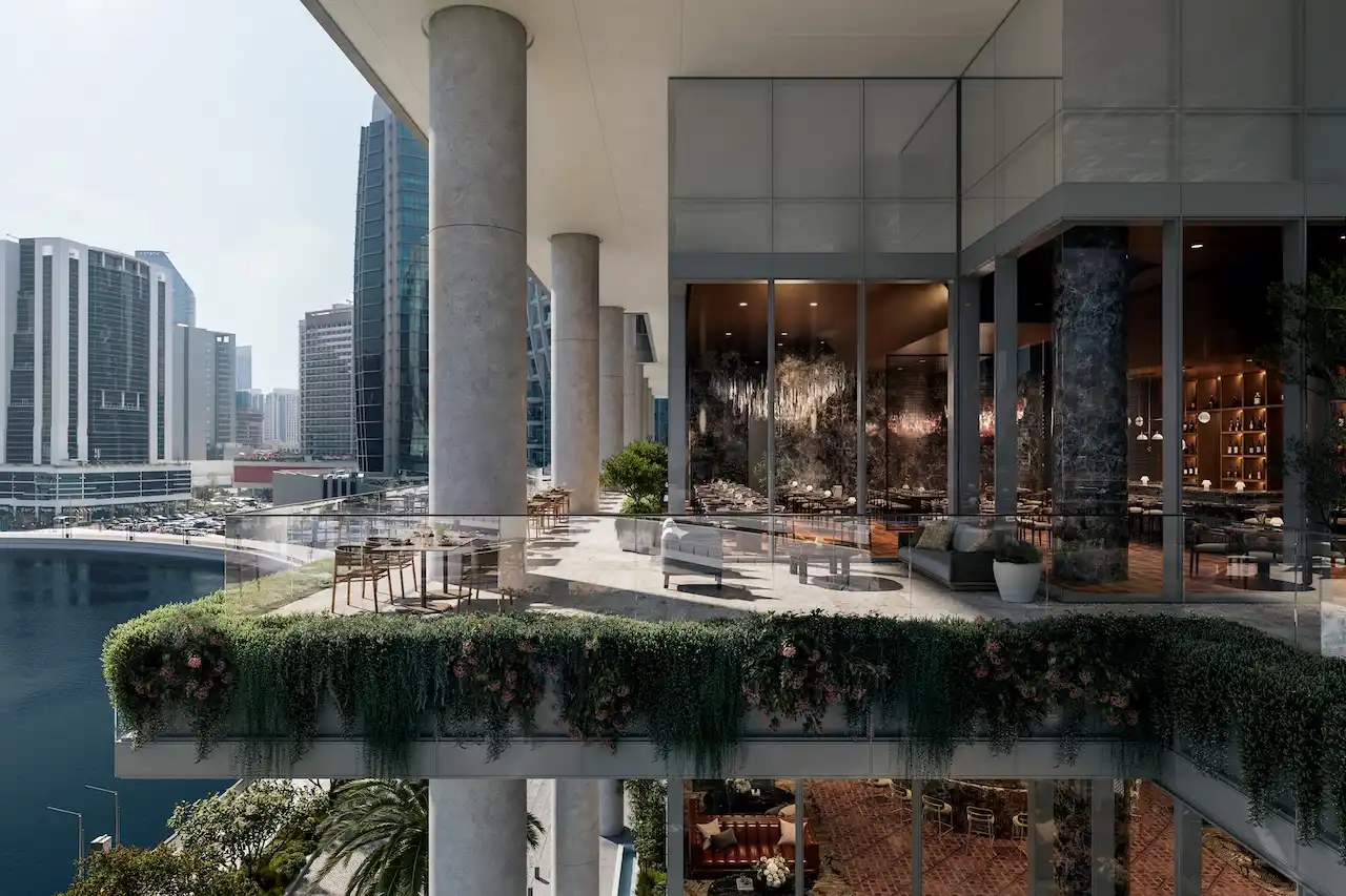 Elevated skydeck terrace at ENARA by OMNIYAT in Business Bay, overlooking the Dubai Canal with outdoor seating, glass façades, and contemporary commercial design. Presented by Tohid Fetrat.