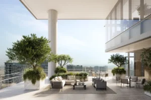 Refined outdoor terrace at ENARA by OMNIYAT in Business Bay, featuring contemporary lounge seating, landscaped planters, structural columns, and open views across Dubai’s urban skyline. Presented by Tohid Fetrat.
