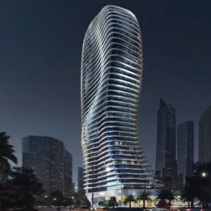 Night exterior view of Bugatti Residences by Binghatti in Business Bay Dubai, showcasing the iconic sculpted tower design inspired by Bugatti automotive curves and illuminated luxury architecture. Presented by Tohid Fetrat.