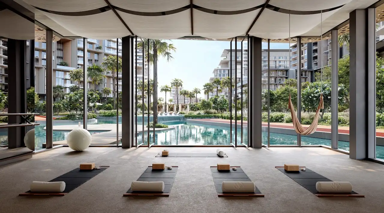City Walk Crestlane by Meraas showing a luxury yoga and wellness studio with floor to ceiling windows relaxation mats natural light and serene views of the lagoon pool and residences presented by Tohid Fetrat.