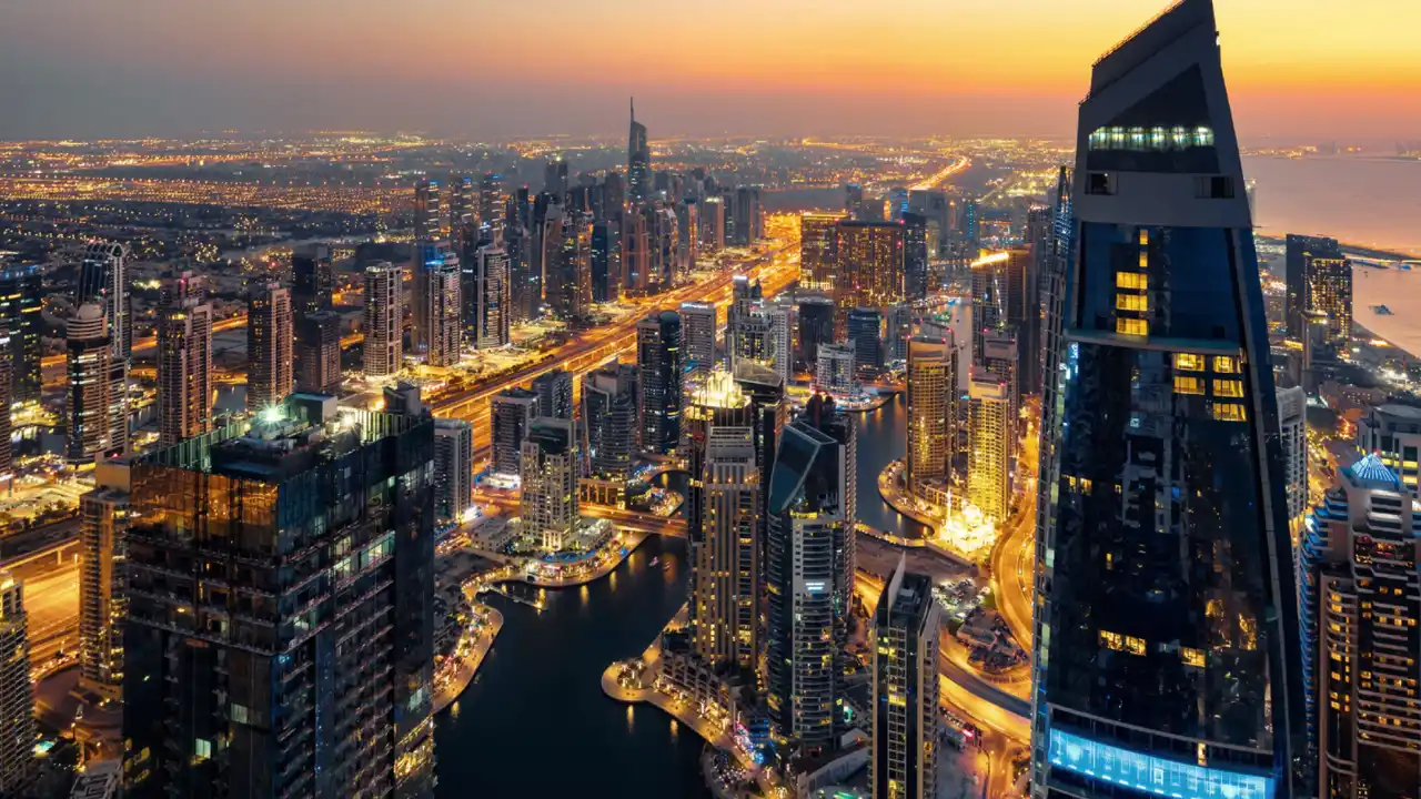 Aerial sunset view of Dubai Marina with illuminated towers and waterfront skyline Presented by Tohid Fetrat