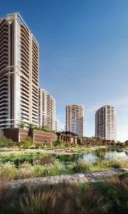 Exterior view of Eltiera Views showcasing modern residential towers, landscaped greenery, and a tranquil lagoon-style water feature in Dubai. Presented by Tohid Fetrat.