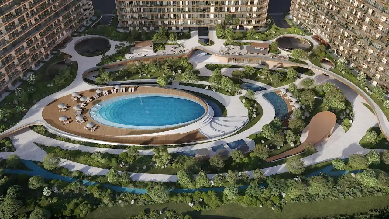 Aerial view of The Cove at Hado in the SIORA community by Beyond featuring the central pool deck landscaped gardens flowing pathways and the organic tower layout presented by Tohid Fetrat.