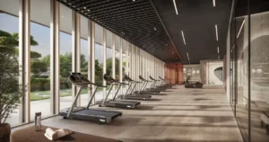 Luxury fitness studio at Hado Tower in the SIORA community by Beyond featuring modern treadmills floor to ceiling windows and serene landscaped garden views presented by Tohid Fetrat.