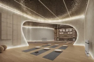 Hado Tower yoga studio in the SIORA community by Beyond featuring a sculpted interior warm lighting yoga mats and wellness equipment presented by Tohid Fetrat.