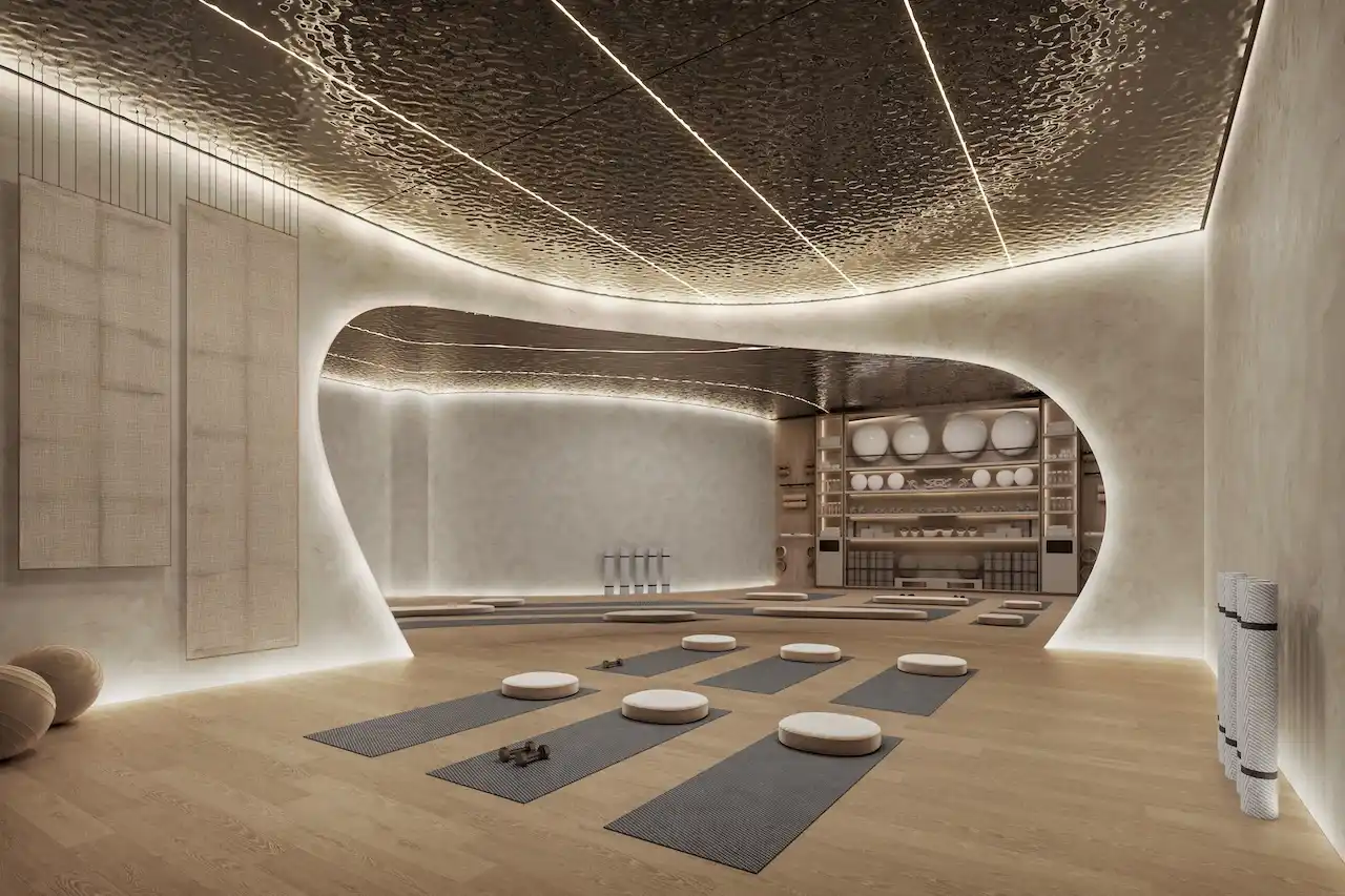 Hado Tower yoga studio in the SIORA community by Beyond featuring a sculpted interior warm lighting yoga mats and wellness equipment presented by Tohid Fetrat.