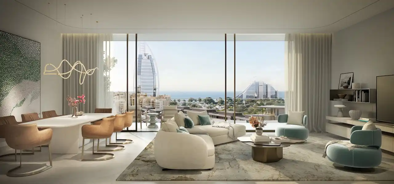 Spacious open plan living and dining area in a 3 bedroom apartment at MJL Nourelle in Madinat Jumeirah Living Dubai, featuring floor to ceiling windows, soft contemporary furniture, dining space and panoramic views toward the Gulf and Burj Al Arab. Presented by Tohid Fetrat.