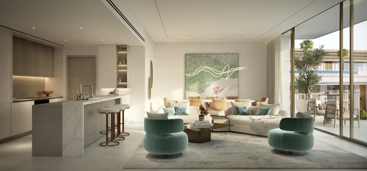 Elegant open plan living room with integrated kitchen in a 3 bedroom apartment at MJL Nourelle in Madinat Jumeirah Living Dubai, featuring soft contemporary seating, marble kitchen island, floor to ceiling windows and refined interior finishes. Presented by Tohid Fetrat.