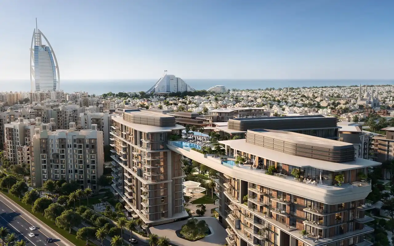 Aerial view of MJL Nourelle in Madinat Jumeirah Living Dubai, showcasing contemporary residential buildings with rooftop amenities, landscaped courtyards and panoramic views toward Burj Al Arab and the Gulf. Presented by Tohid Fetrat.