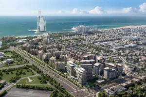 Aerial view of MJL Nourelle at Madinat Jumeirah Living Dubai, showcasing low-rise residential buildings, landscaped boulevards, premium community planning and proximity to Burj Al Arab and the Gulf waterfront. Presented by Tohid Fetrat.