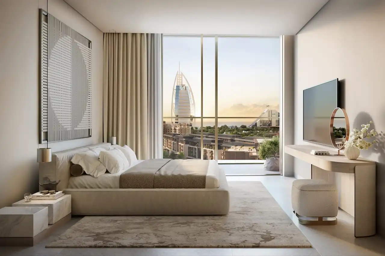 Master bedroom interior at MJL Nourelle in Madinat Jumeirah Living Dubai, featuring a serene modern design, floor to ceiling windows, refined neutral finishes and a direct view of Burj Al Arab. Presented by Tohid Fetrat.