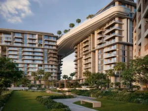 Central garden and sky bridge view of MJL Nourelle in Madinat Jumeirah Living Dubai, featuring contemporary residential buildings, elevated architectural connection, landscaped green spaces and a refined community atmosphere near the Gulf. Presented by Tohid Fetrat.