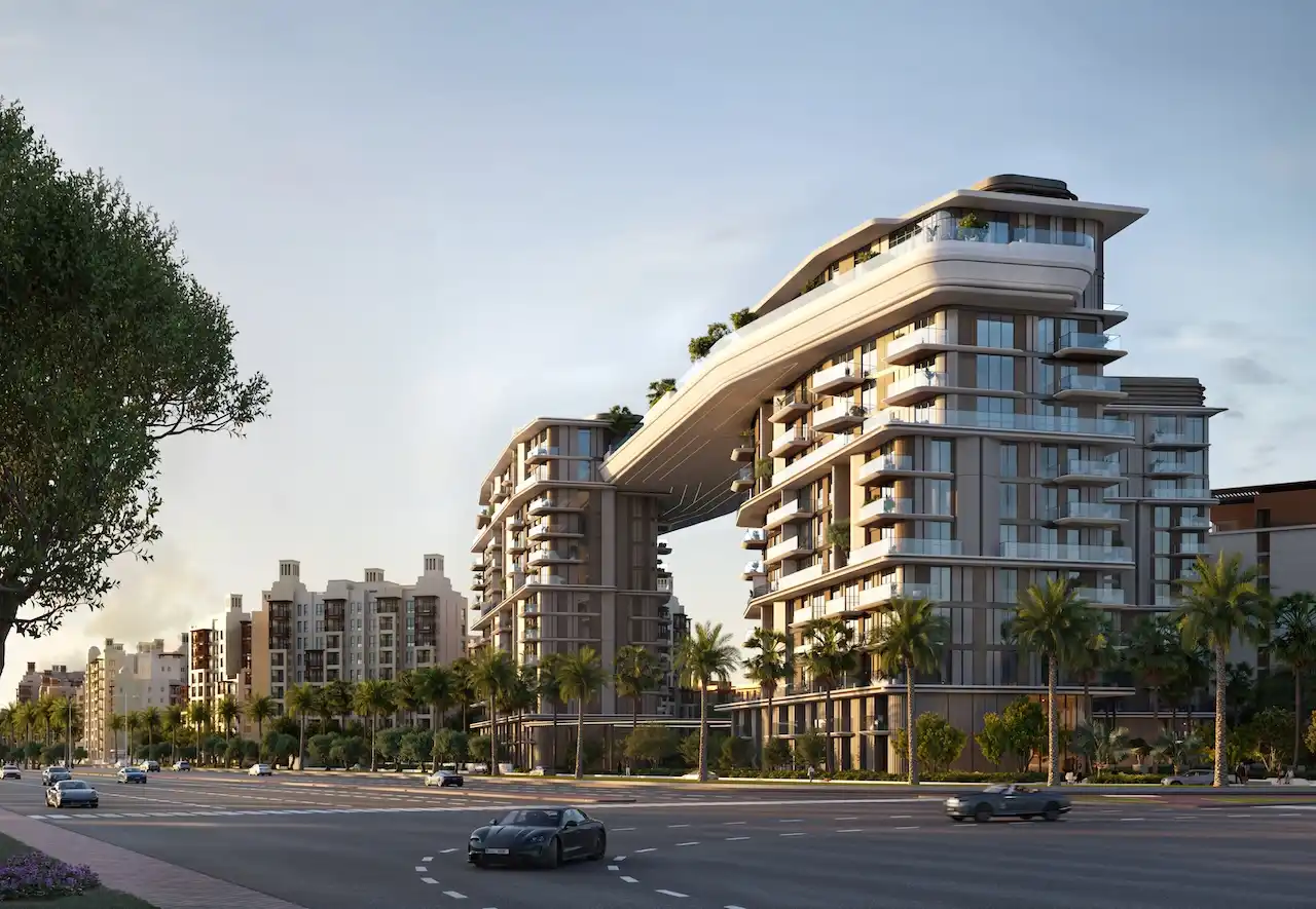 Contemporary exterior architecture of MJL Nourelle in Madinat Jumeirah Living Dubai, showcasing connected residential towers with an iconic sky bridge, palm lined boulevards and a premium urban setting. Presented by Tohid Fetrat.