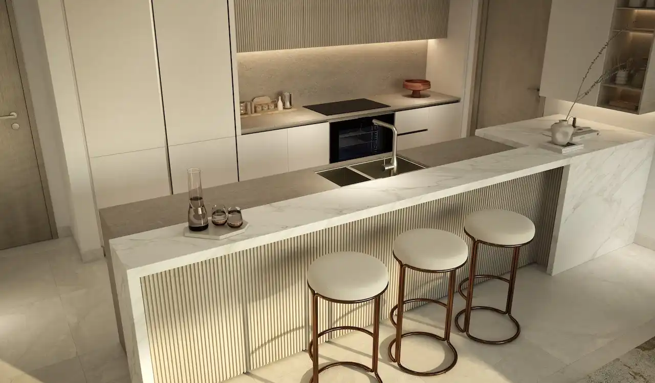 Modern open plan kitchen at MJL Nourelle in Madinat Jumeirah Living Dubai, featuring marble island, integrated appliances, minimalist cabinetry, breakfast bar seating and a refined neutral interior design. Presented by Tohid Fetrat.