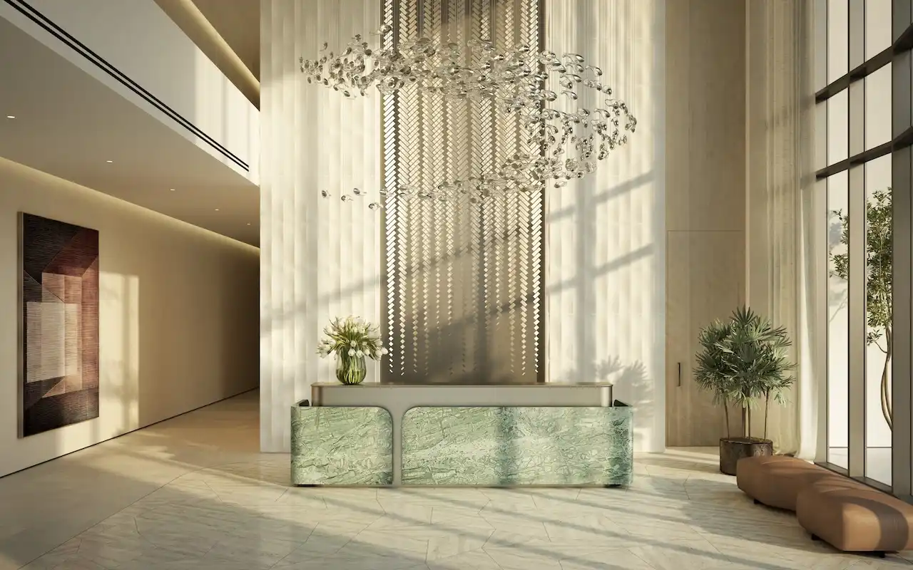 Reception area and main lobby at MJL Nourelle in Madinat Jumeirah Living Dubai, featuring double height ceilings, sculptural chandelier, refined stone finishes and a luxury residential welcome space. Presented by Tohid Fetrat.