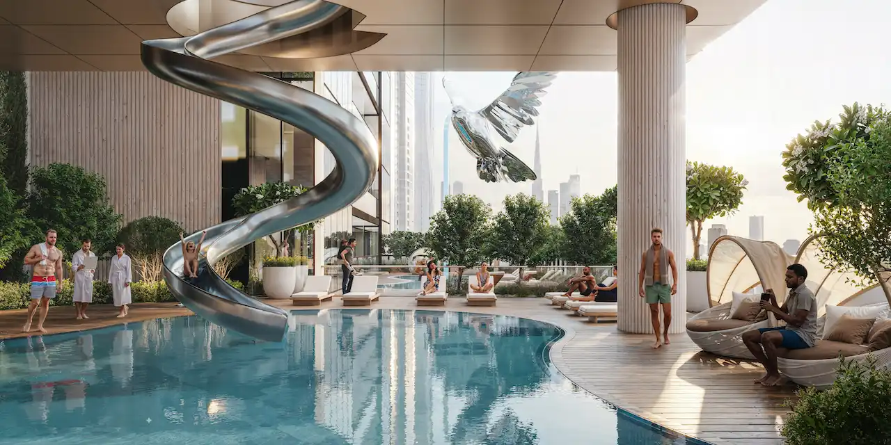 Sobha SkyParks family pool and play zone featuring a resort style swimming area with water slide, sun loungers, and landscaped surroundings presented by Tohid Fetrat.
