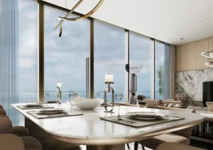 Sea view living and dining area at Sobha SkyParks featuring floor to ceiling windows, marble dining table, and modern interior design in Dubai presented by Tohid Fetrat.