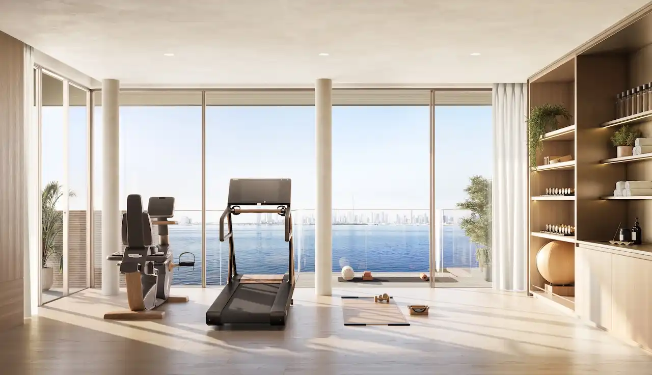 Penthouse private gym interior at Solaya by Meraas in Dubai, featuring modern fitness equipment, floor to ceiling windows, serene waterfront views and a refined wellness focused design. Presented by Tohid Fetrat.