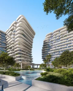 Central water feature and landscaped garden at Arival Piazza Passo by Beyond, showcasing sculptural curved residential towers, cascading water elements, lush greenery, and contemporary resort style architecture in Dubai. Presented by Tohid Fetrat.