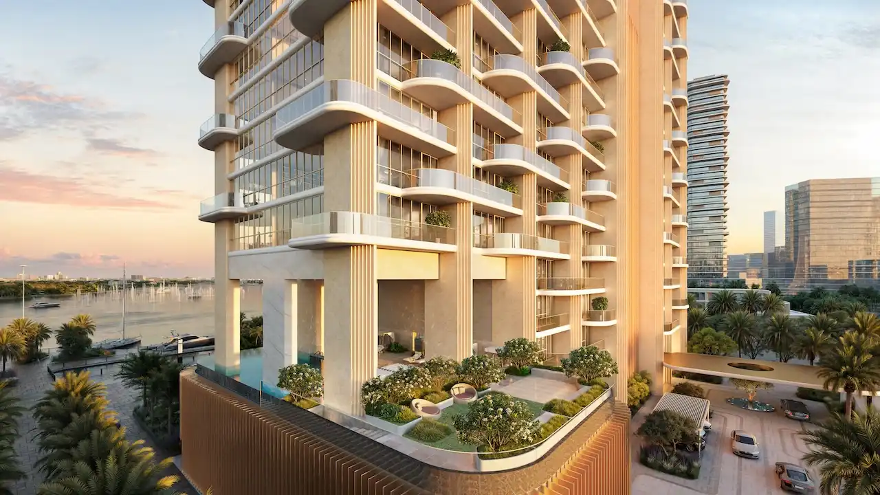 Elevated residential podium at Atelis at d3 showcasing sculptural columns, curved balconies, landscaped gardens, and waterfront surroundings within Dubai Design District. Presented by Tohid Fetrat.