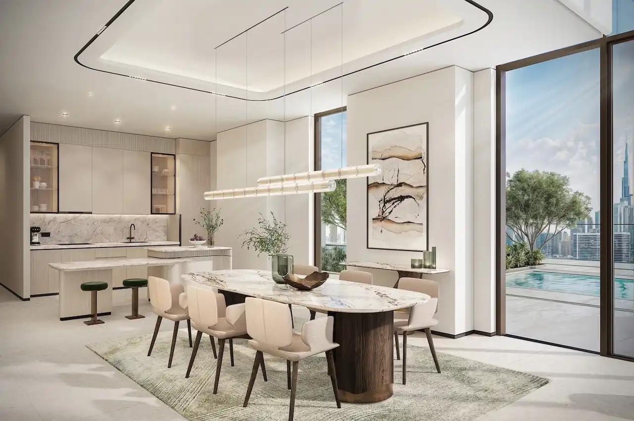 Sky villa dining area at Atelis at d3 featuring an open-plan kitchen, marble dining table, contemporary lighting, and floor-to-ceiling glass with terrace and skyline views in Dubai Design District. Presented by Tohid Fetrat.