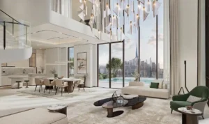 Double-height living area in a sky villa at Atelis at d3 featuring floor-to-ceiling windows, sculptural lighting, open-plan dining space, and panoramic city views over Dubai Design District. Presented by Tohid Fetrat.