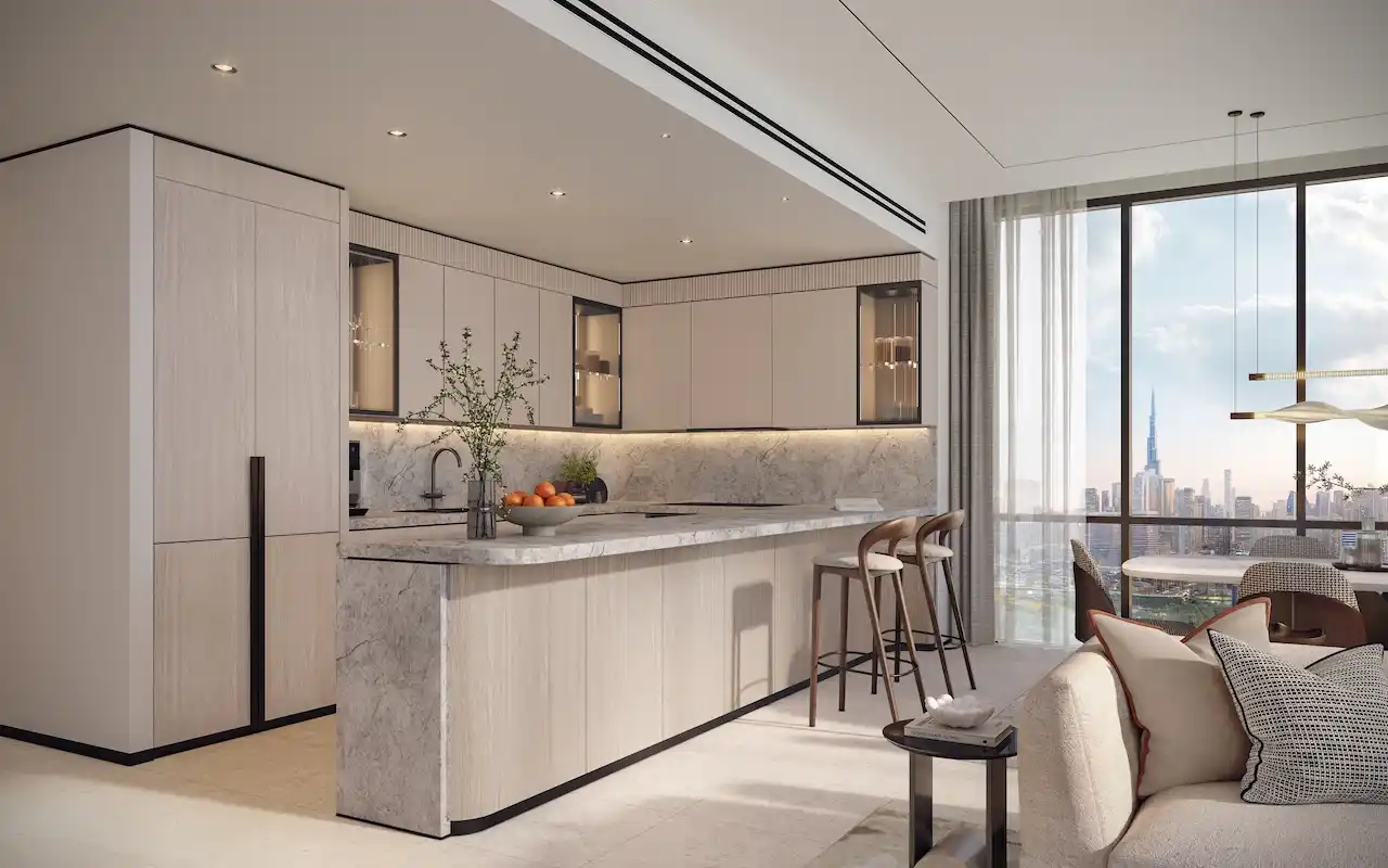 Open-plan kitchen in a typical residence at Atelis at d3, featuring a marble island, integrated cabinetry, modern finishes, and floor-to-ceiling windows with Dubai skyline views in Dubai Design District. Presented by Tohid Fetrat.