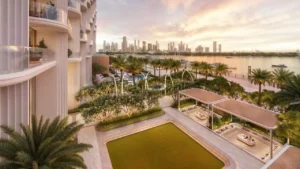Waterfront garden amenities at Atelis at d3 featuring landscaped green spaces, shaded seating areas, palm-lined walkways, and serene views across the creek and Dubai skyline. Presented by Tohid Fetrat.