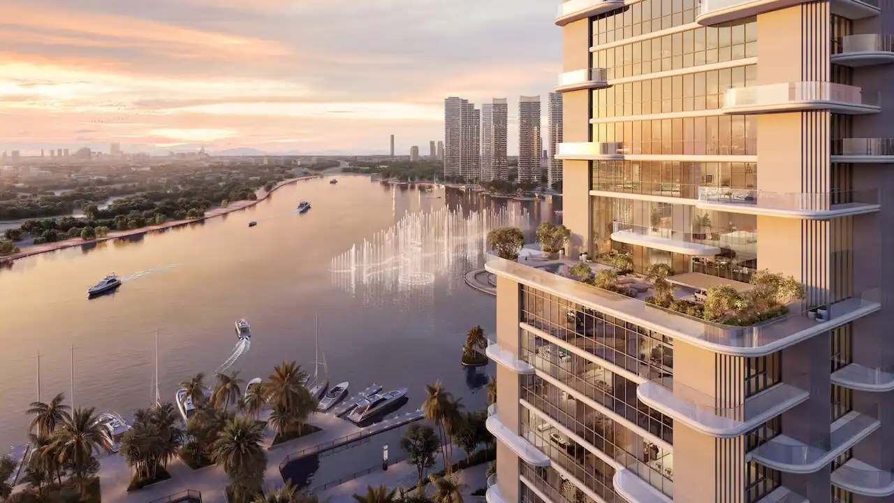 Waterfront residential tower at Atelis at d3 overlooking Dubai Creek, featuring contemporary glass façades, private terraces, marina views, and sunset skyline scenery in Dubai Design District. Presented by Tohid Fetrat.