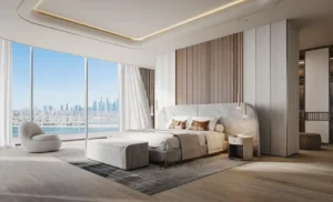 Master bedroom at Bella at Passo by Beyond featuring floor-to-ceiling windows, refined contemporary design, soft neutral palette, integrated wardrobe wall, and panoramic views toward Palm Jumeirah and Dubai skyline, Presented by Tohid Fetrat