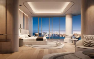 Penthouse master bedroom at Bella at Passo by Beyond featuring floor-to-ceiling windows, refined contemporary interior design, soft neutral tones, and panoramic night views over Palm Jumeirah and the Dubai skyline, Presented by Tohid Fetrat