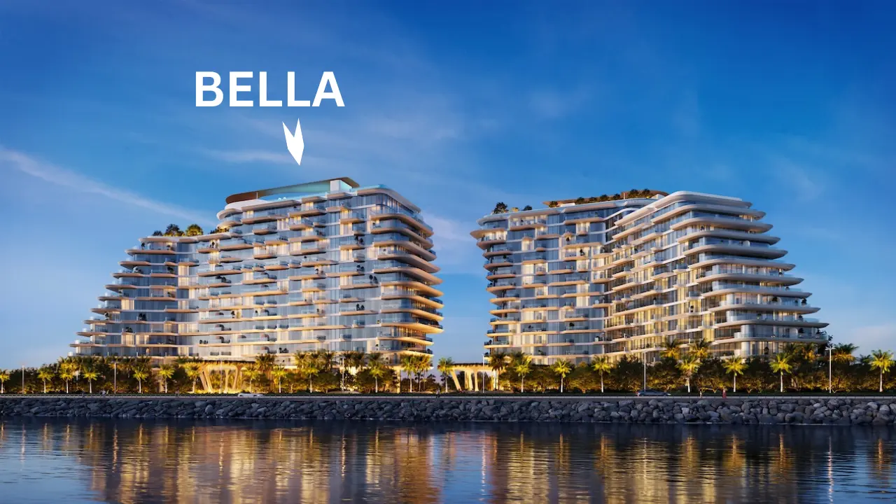 Waterfront evening view of Bella at Passo by Beyond on Palm Jumeirah featuring stepped contemporary architecture, illuminated façades, palm lined promenade, and reflections across the calm shoreline waters in Dubai. Presented by Tohid Fetrat.