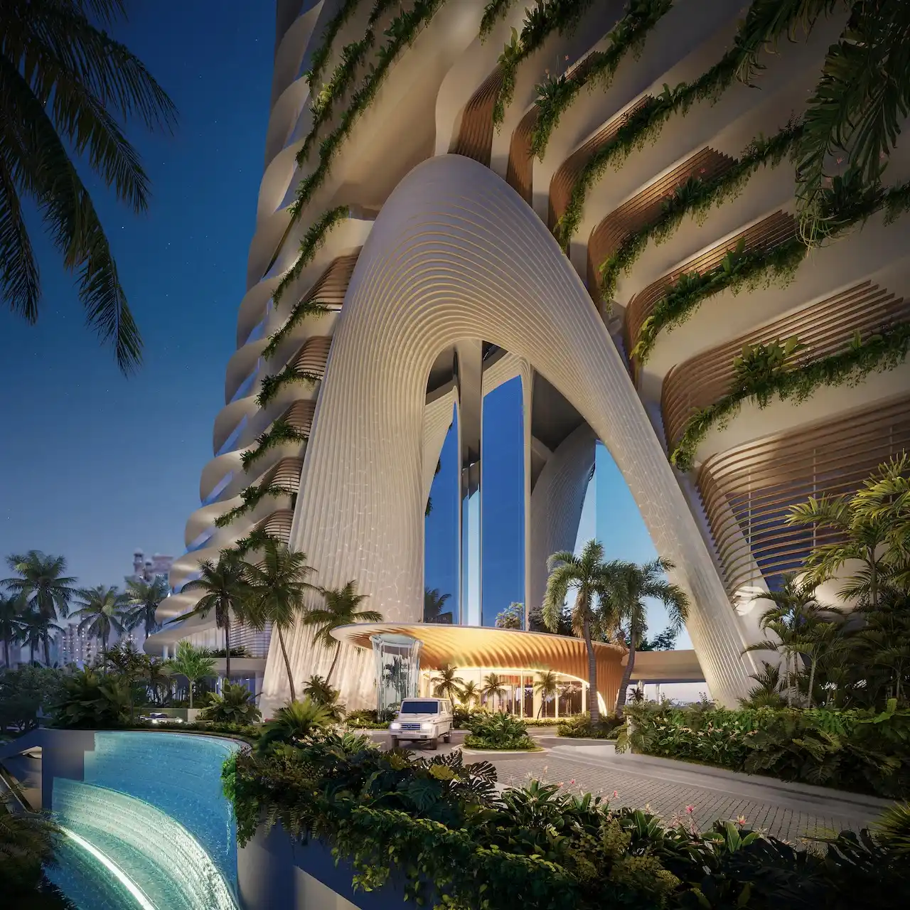 Architectural entrance of COMO Residences featuring a sculptural curved façade, vertical arch structure, layered balconies with integrated greenery, landscaped arrival court, and refined drop off experience on Palm Jumeirah in Dubai. Presented by Tohid Fetrat.