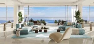 Luxury living room at COMO Residences on Palm Jumeirah with a balanced open-plan layout, floor-to-ceiling glass walls, elegant contemporary seating, and uninterrupted Gulf views. Presented by Tohid Fetrat.