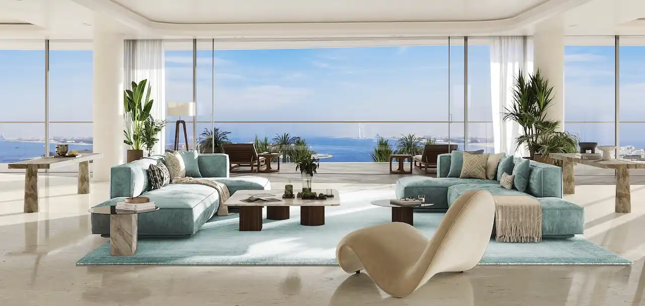 Luxury living room at COMO Residences on Palm Jumeirah with a balanced open-plan layout, floor-to-ceiling glass walls, elegant contemporary seating, and uninterrupted Gulf views. Presented by Tohid Fetrat.