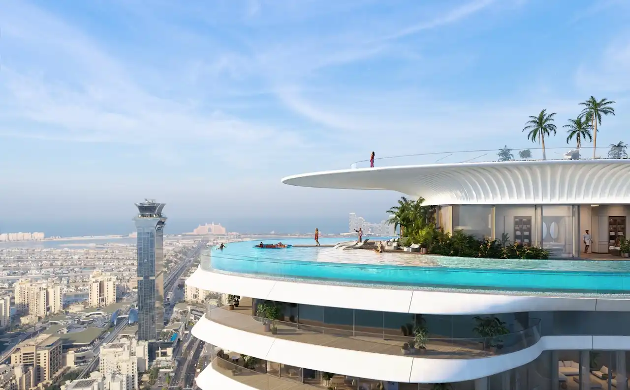 Rooftop infinity pool at COMO Residences featuring an elevated swimming pool, sculpted white architecture, panoramic Dubai skyline views, and Palm Jumeirah coastal surroundings. Presented by Tohid Fetrat.